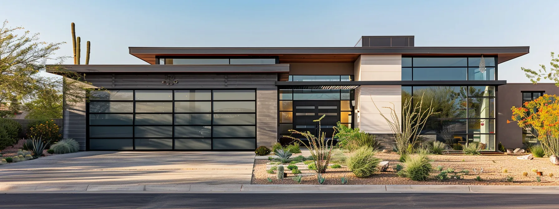 Modern home exterior featuring a sleek garage door, large windows, and desert landscaping, illustrating energy-efficient design for Phoenix residences.